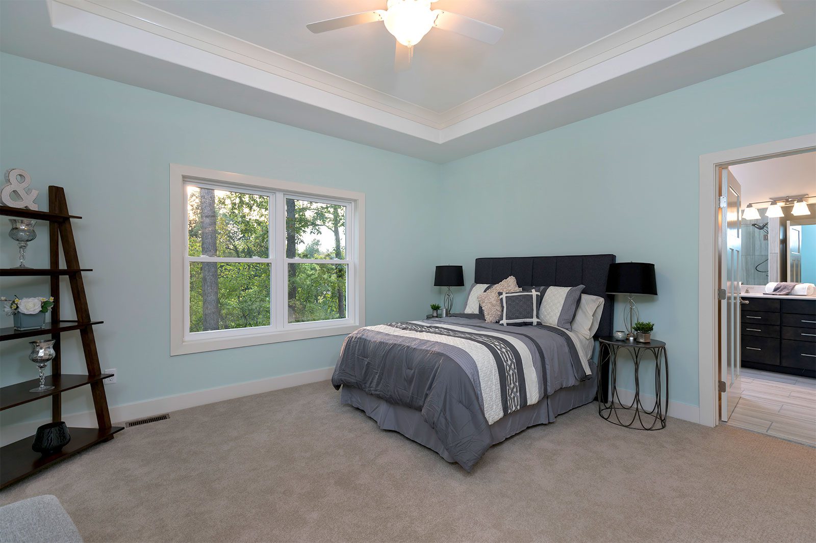 The bedroom with tray ceiling and ensuite master bathroom from a luxury home from the Villas at Blystone in Monclova, Ohio, constructed by the team at Miller Diversified